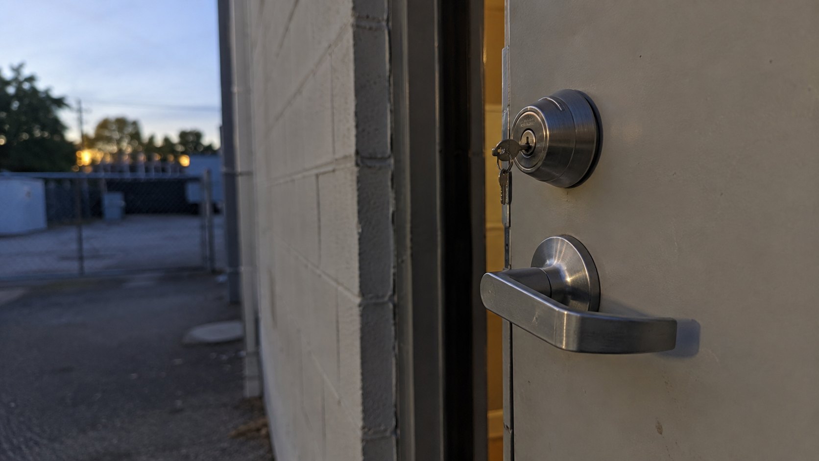 The service entrance of a small business at closing time with a key in the deadlock