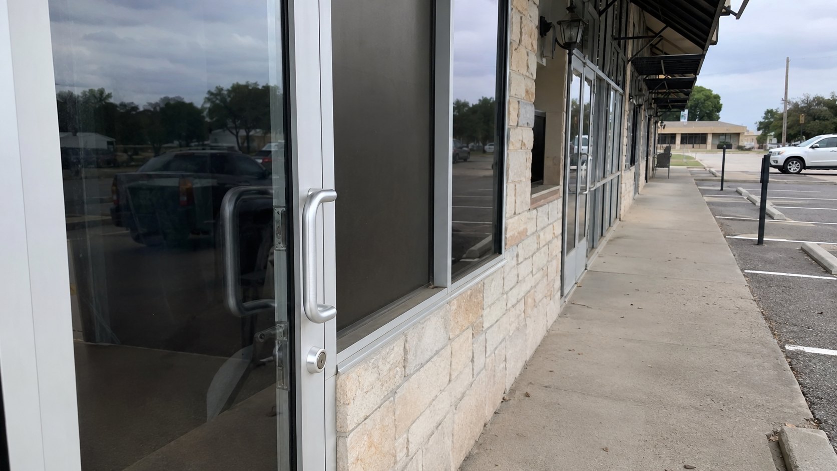 A row of local shopfronts in a North Texas town with aluminium and glass doors