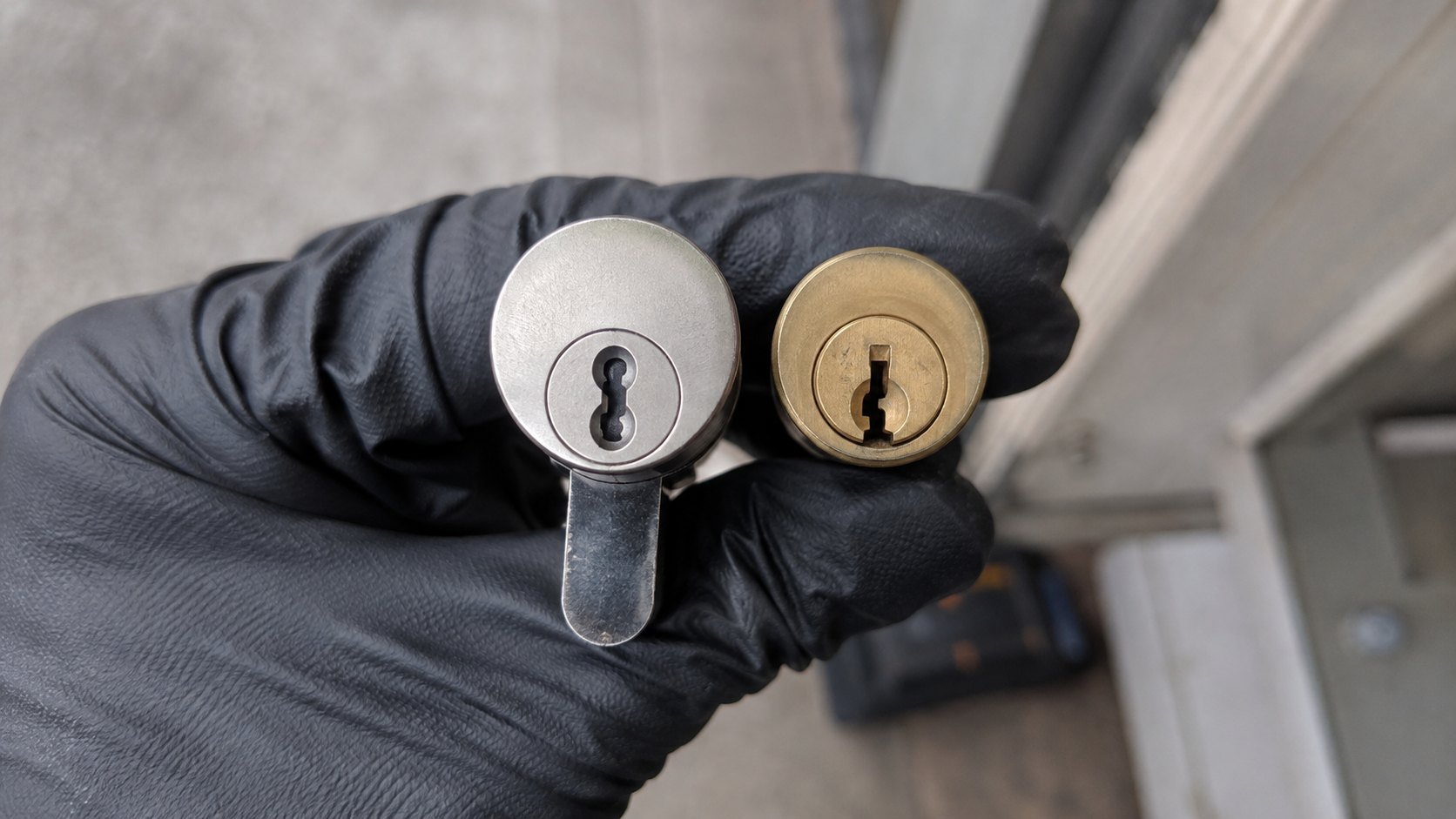A restricted-keyway high security cylinder held beside an ordinary one