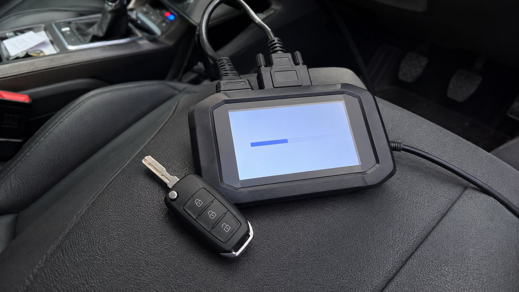 An encrypted European car key beside a professional programming device